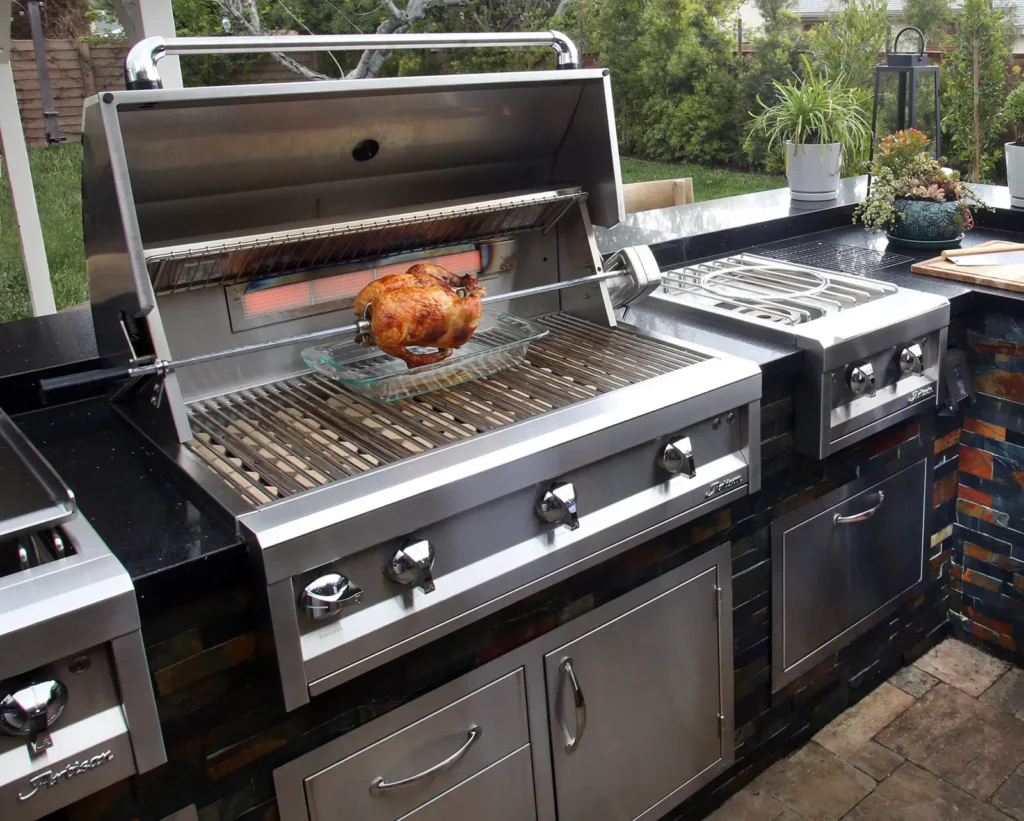 Outdoor kitchen island with built-in gas grill, side burner and stainless steel cabinetry